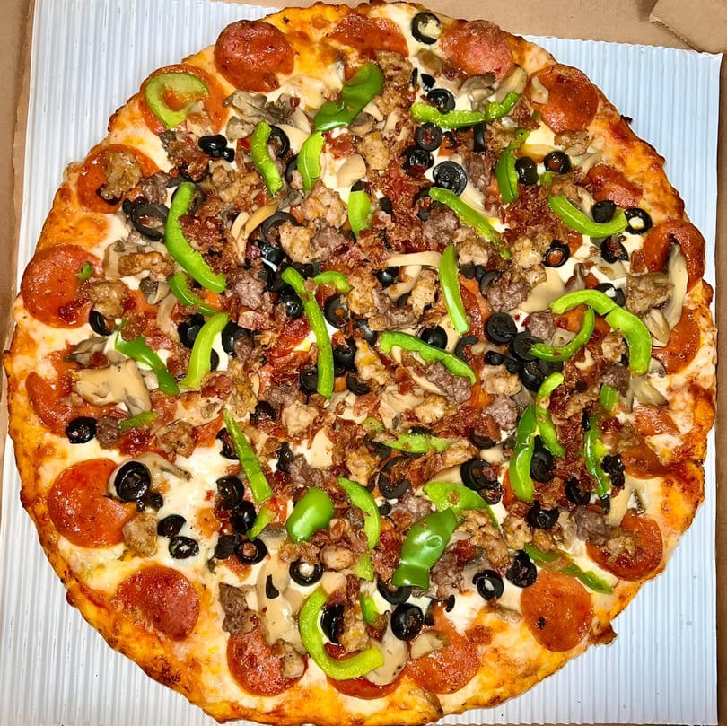 A Sunnyside Pizza with pepperoni, sausage, mushrooms, black olives, and green peppers.